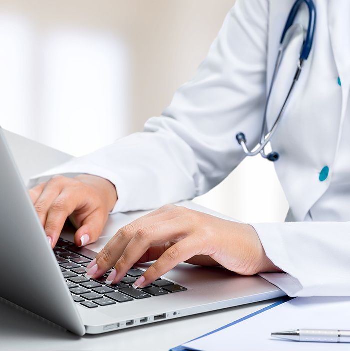 Eine Ärztin arbeitet an ihrem Laptop.